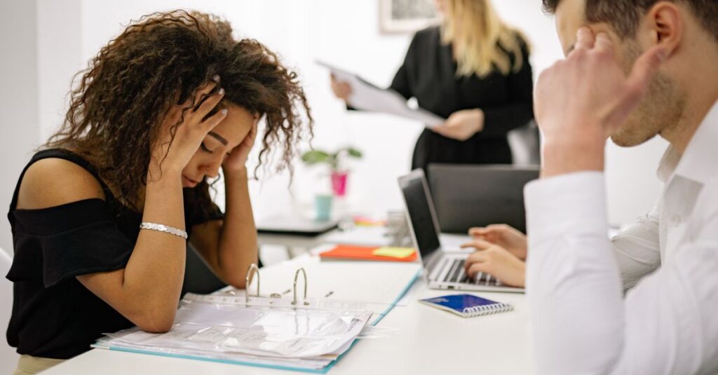 Oficina con empleados mostrando señales de estrés y angustia emocional, reflejando el impacto del entorno laboral en la salud mental.