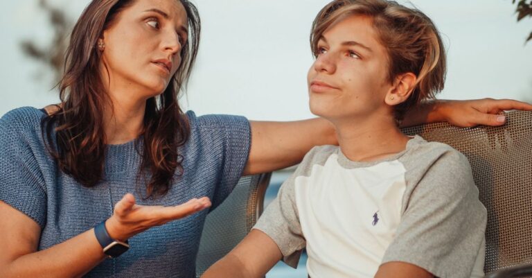 Una madre y su hijo adolescente conversando en un ambiente natural, simbolizando la importancia de la comunicación en la familia.