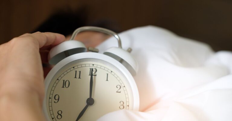 Una persona despertando con expresión de angustia en un ambiente de dormitorio, representando el tema de despertar angustiado.