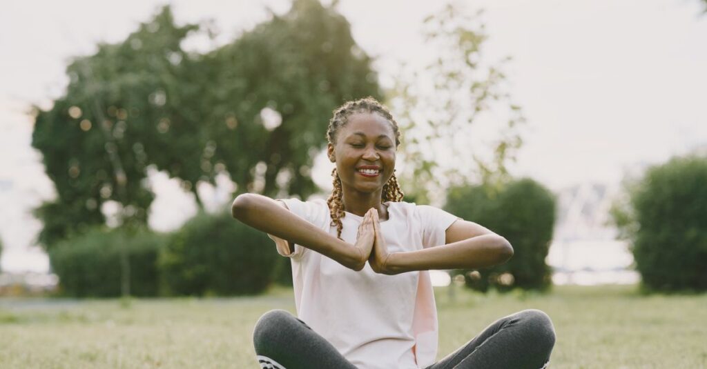 Una persona meditando en un entorno natural, simbolizando la conexión con el presente y la búsqueda de la felicidad.