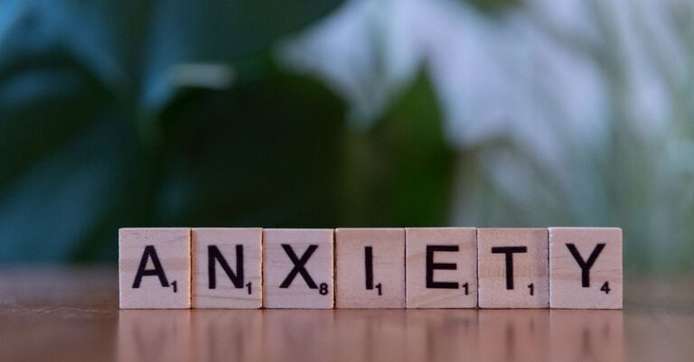Una persona con expresión de ansiedad al despertar, mostrando la lucha interna que experimenta al inicio del día.