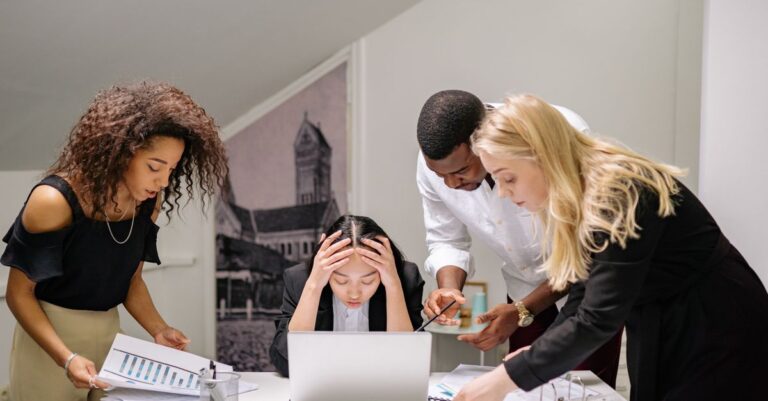 Una persona sentada en un escritorio con expresión de tristeza, simbolizando la falta de motivación en el trabajo.