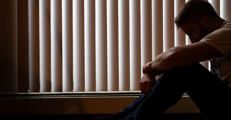 Una persona mirando por la ventana con una expresión reflexiva, simbolizando la introspección y la búsqueda de ayuda ante la depresión leve.