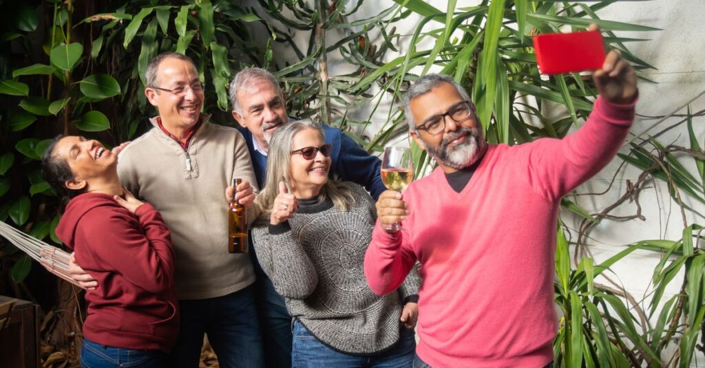 Grupo de adultos interactuando y sonriendo en un entorno social, reflejando la búsqueda de nuevas amistades.