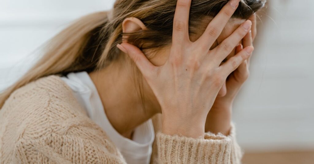 Una persona mirando por la ventana con una expresión melancólica, simbolizando la tristeza tras un cambio significativo en la vida.